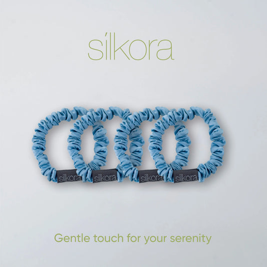 Vier kleine Silkora scrunchies in icy blauw op een lichte achtergrond met het Silkora-logo en de tekst "Gentle touch for your serenity".