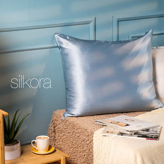 Hellblauer Seidenkissenbezug von Silkora auf einem Kissen